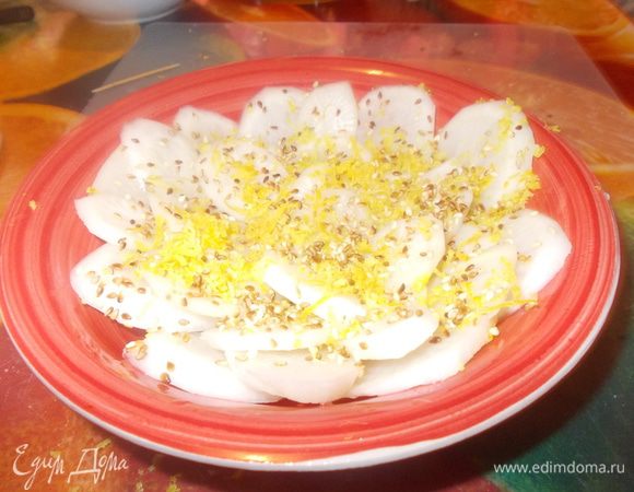 кунжутные семечки обжарить.рисовый уксус перемешать с сахаром,до растворения.дайкон очистить и нарезать колечками,уложить в глубокое блюдо слоями,полить заправкой посыпать щедро лимонной цедрой и присыпать семечками.убрать на 30 минут в холодильник.приятного аппетита.