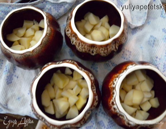 На дно глиняных чашек положить по кусочку топленого масла, картофель, капусту, 