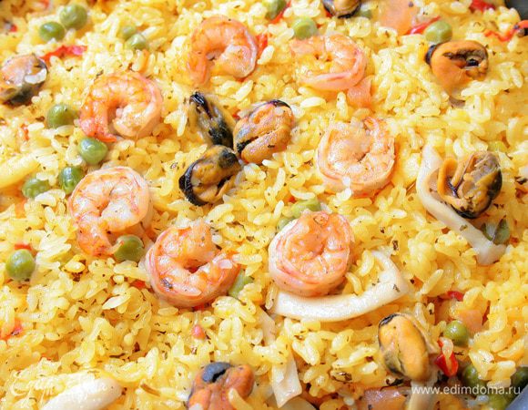 Положите креветки и мидии и доведите рис до готовности.