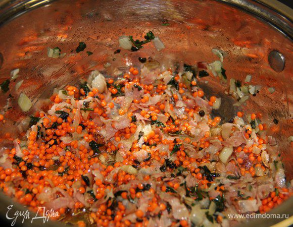 Разогреть в кастрюле с толстым дном масло, обжарить до золотистой корочки все нарезанные ингредиенты. Всыпать чечевицу и обжарить ещё несколько минут.