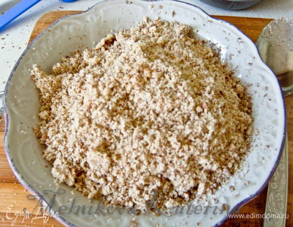 Измельчить орехи. Признаюсь, я поленилась и измельчила в блендере. В результате получилось слишком мелко. Порекомендовала бы измельчать при помощи доски и скалки, чтобы кусочки были крупнее.