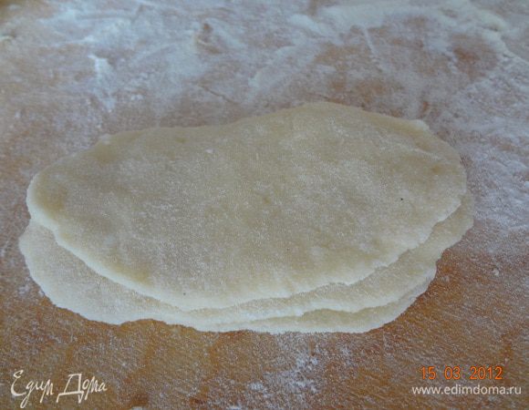 Раскатать тесто в пласт толщиной 3-4 мм, чтобы получились овалы. Выложить друг на друга и свернуть в рулетик. 