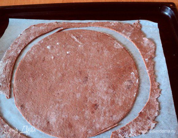 Каждую часть тонко раскатать, выложить на бумагу для выпечки и вырезать круг нужного диаметра. Я вырезала по донышку разъемной формы Ф-23 см. Обрезки оставить на бумаге, они в дальнейшем пригодятся для приготовления посыпки. Выпекать при температуре 200 градусов 7-10 мин.