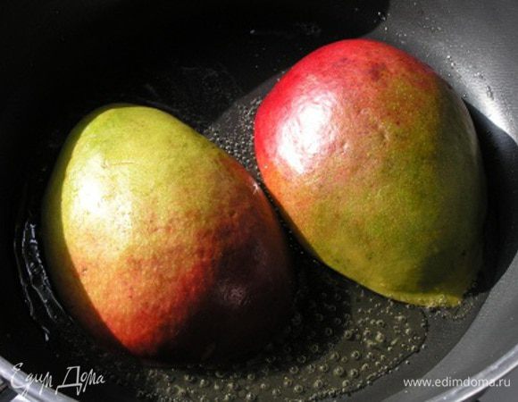 Манго разрезать вдоль пополам и удалить косточку. В сковороде растопить сливочное масло, обжарить половинки манго вместе с половиной меда до золотистого цвета около 5 минут.