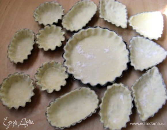 Наполнить формочки тестом, хорошо прижав его к стенкам. Сделать это гораздо легче, если всыпать пару щепоток муки в формочку на тесто. Присыпанное мукой тесто станет намного послушней и отлично заполнит всю формочку. Желательно поставить формочки, заполненные тестом, в морозильник на 10 минут.