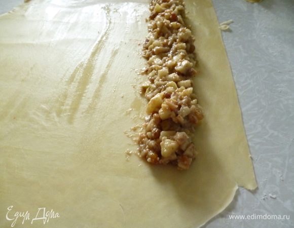 Выложите начинку «колбаской», отступив от края теста примерно на 5 см.