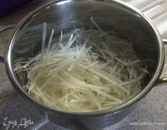 Рисовую лапшу поломать на мелкие части 3-4 см. Залить кипятком и оставить на 10 минут.