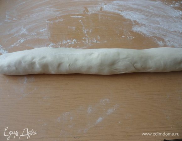 Через 2 часа достаем тесто и скатываем его в колбаску.