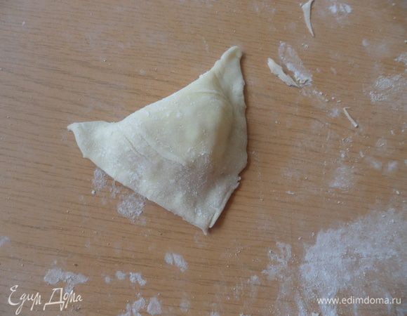 Делаем из теста треугольничек и так со всеми остальными частями. Складываем слойки на смазанный маслом противень и ставим в разогретую духовку на средний огонь.