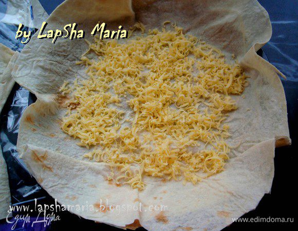 Берем форму с низкими бортами (для пирогов или пиццы). Укладываем один слой лаваша, присыпаем сыром обильно.