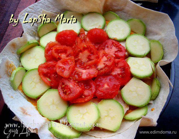 На помидорах сделаем надрезы крестом у основания и ошпарим кипящей водой. Можно оставить их минут на 5 в горячей воде. Затем легко снимем кожуру и нарежем помидоры кольцами. Кабачок нарежем ооочень тоненько. Выложим по внешнему краю кабачок, а в середину помидоры.