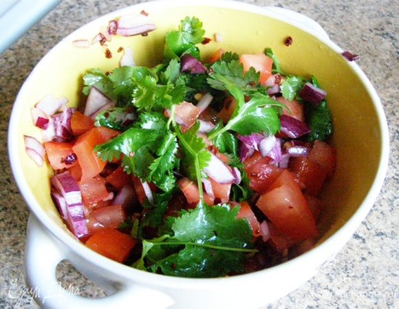 Смешаем в миске помидоры, лук, сок половины лайма, половину листьев кинзы. Посолим и поперчим. 