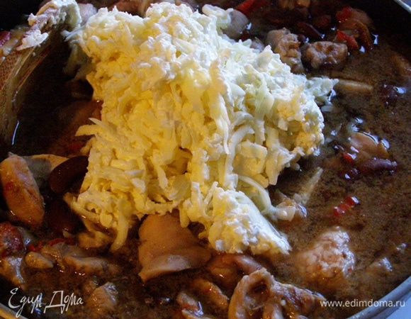 Через положенное время добавим сыр к курице. Крышкой не накрываем. Тушим еще минут 20.