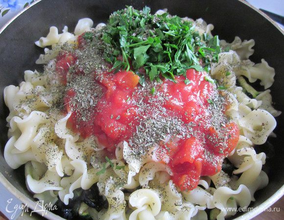 Отварить пасту и добавить её в сковороду к маслинам и цукини. Добавить помидоры, петрушку, базилик.