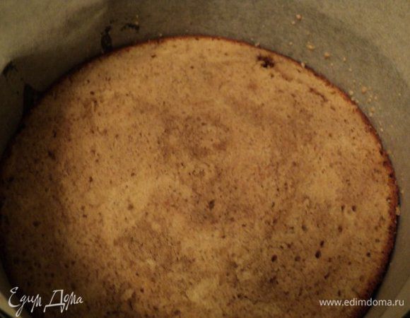 Установить на блюдо разъемное кольцо, бока выложить бумагой для выпечки. На дно положить пласт бисквита.