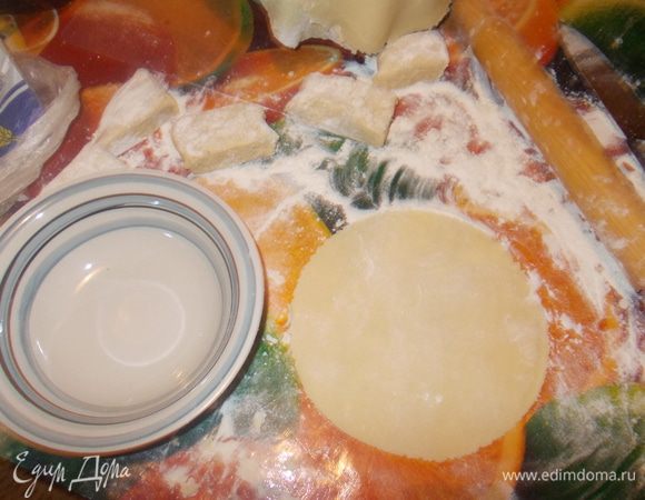 Каждую часть раскатать скалкой в пласт, посыпая мукой с обеих сторон.
Сверху на раскатанный пласт теста положить тарелку и вырезать круглый корж 