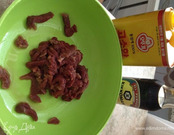 Говядину мелко нарежьте, смешайте с соевым соусом и кунжутным маслом. Оставьте мариноваться на 30 минут.