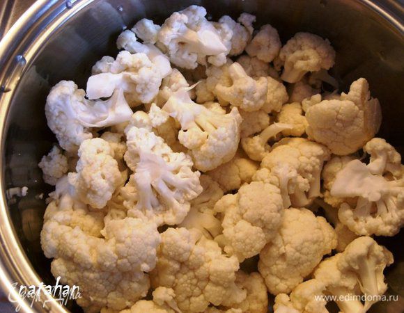 Цветную капусту разобрать на небольшие соцветия, помыть, обсушить, добавить в кастрюлю и  перемешать. 