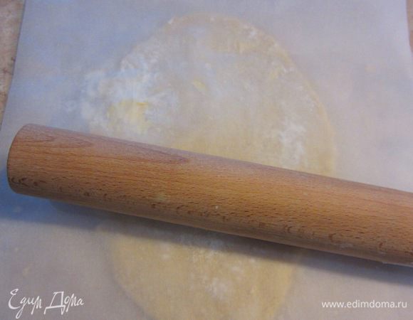 Достаньте тесто. Половину теста раскатайте в пласт толщиной около сантиметра. У меня форма овальная, поэтому я раскатывал тесто овальной формы. Для того, чтобы тесто не разошлось можете раскатывать его между пергаментной бумагой, как это делал я. Также потом будет легко выкладывать тесто в форму.