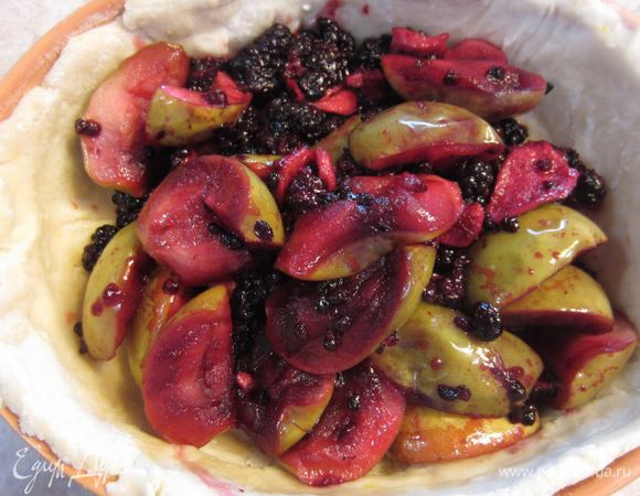 Выложите начинку на тесто горкой. Вылейте в начинку половину сока, оставшегося после варки фруктов.
Взбейте отдельное яйцо и смажьте края яйцом.