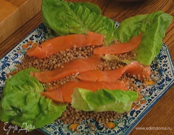 Гречку выложить на блюдо, украсить листьями латука, сверху поместить нарезанную семгу, сбрызнуть оливковым маслом.