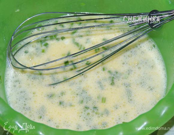 Для омлета взбить яйца  венчиком. Добавить измельченный шнитт-лук и выдавить зубчик чеснока. Смешать.