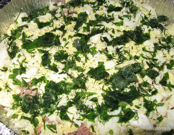 Выливаем половину теста в форму, выкладываем тунец, на него рубленые яйца,а сверху зелень 