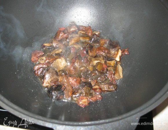 В казане разогрел три столовых ложки растительного масла, выложил грибы и обжарил. 