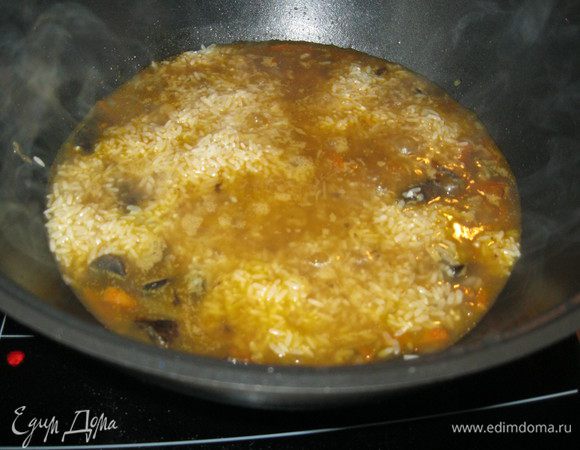 Через пять минут, вынул головку чеснока, долил полтора стакана горячей воды, а сверху положил рис, предварительно откинув его в дуршлаг. Для цвета, высыпал на рис половину чайной ложки куркумы. Осталось накрыть крышкой и ждать. Пару раз я заглядывал в казан, что бы проверить, не надо ли долить воды.