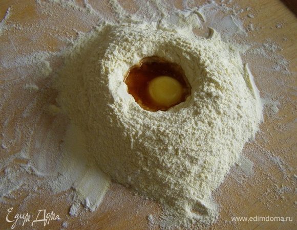 Кукурузную муку можно не использовать, а все тесто замесить из пшеничной, но с кукурузной мукой печенюшки получаются наряднее. Смешаем вместе пшеничную, кукурузную муку и разрыхлитель. Просеем на доску горкой. В центре сделаем углубление, вольем ром, добавим желток, чуть перемешаем
