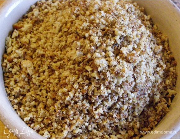 Грецкие орехи обжарим на сухой сковороде, раскатаем скалкой на разделочной доске до очень мелких крошек. Или пробьем в блендере