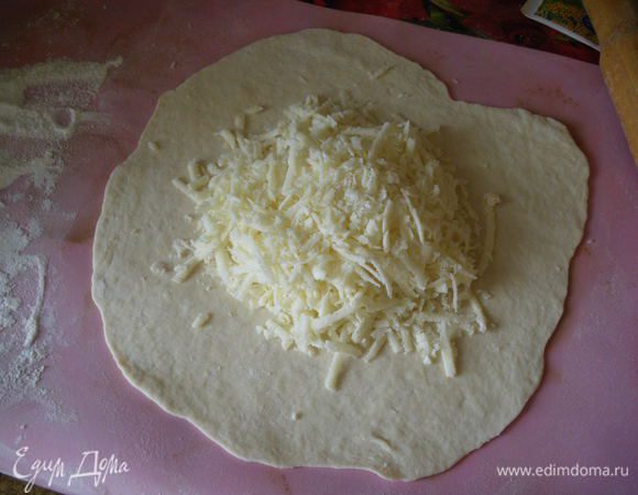 Теперь на припорошенном мукой столе раскатайте небольшие лепешки (по диаметру сковороды), выложите начинку. 