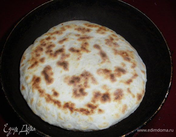 Выложите лепешку на хорошо разогретую сухую сковороду. Накройте крышкой и жарьте на довольно сильном огне 5 минут, переверните и подрумяньте хачапури с другой стороны под крышкой. 