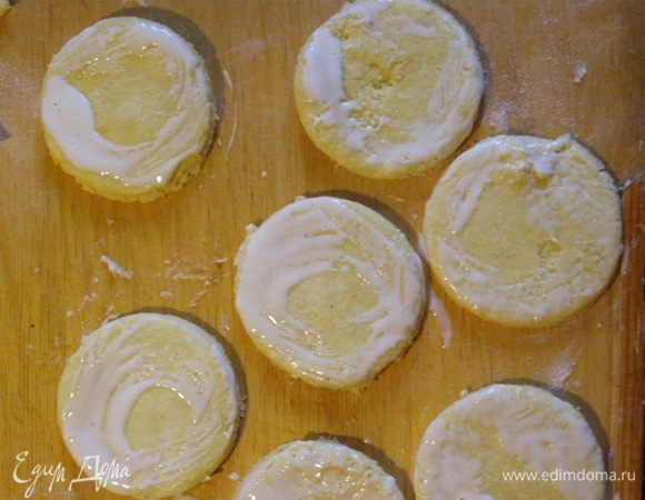 Формочкой (стаканом) вырежем кружки, смажем края смесью сливок и желтка
