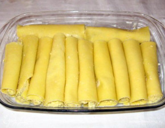 Форму для выпечки смазать сливочным маслом и выложить в неё каннелони.