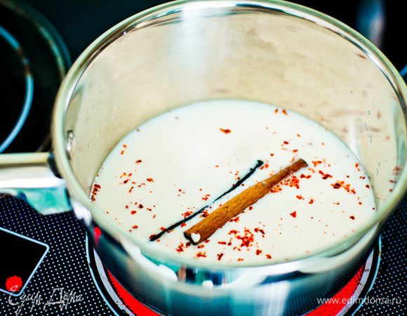 Стручок ванили разрежьте пополам. Прогрейте молоко с ванилью, палочкой корицы и порошком чили в течение одной минуты.