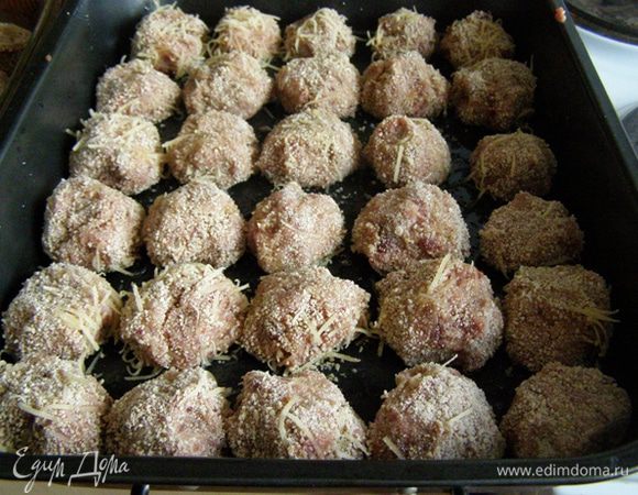 Сформуем фрикадельки диаметром 4-5 см. Обваляем в панировочной смеси. выложим на смазанный маслом противень. Здесь возможны варианты: запечь фрикадельки без соуса (соус подать отдельно) или под соусом. И так и так получается вкусно. Если будете запекать без соуса, то фрикадельки прежде, чем поставить в духовку, нужно сбрызнуть маслом