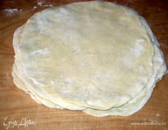 Сложить диски вместе один на другой и снова раскатать. Должен получится круглый пласт теста, которым можно будет накрыть форму для выпечки так, чтобы края свешивались наружу.