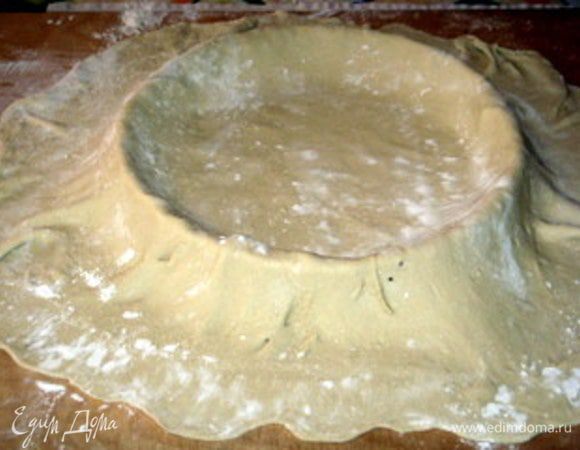 Накрыть форму для выпечки пергаментом. Разместить в ней пласт теста.