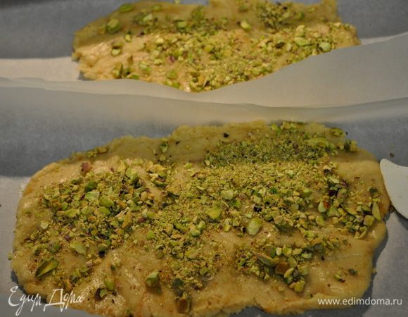 Разделим тесто на 2 части, распределив его на пергамен. бумагу. Сверху обсыпаем фисташками.  