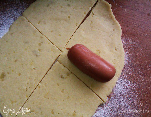 раскатать тесто.чтоб тесто не липло к столу надо посыпать мукой.нарезать прямоугольниками.с сарделек снять пленку и завернуть в тесто.получатся такие пирожки.