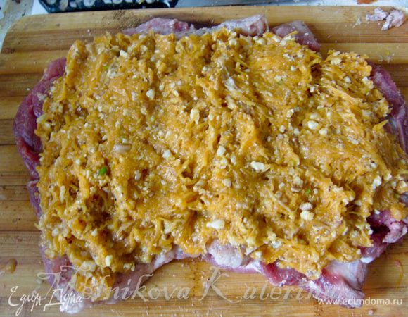 Выложить на мясо начинку, предварительно отжав ее немного от выделившегося сока. 