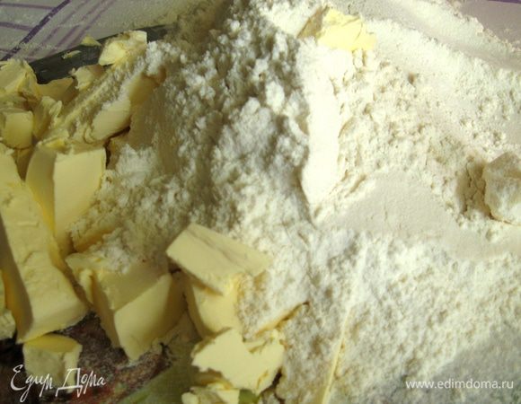 Холодный маргарин (ни в коем случае нельзя повторно замораживать) режем кусочками, кладем к муке. 