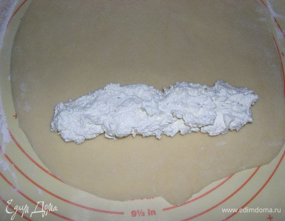 Тесто разделываем на кусочки, формируем шарики и каждый шарик раскатываем на припорошенной мукой доске, выкладываем начинку.