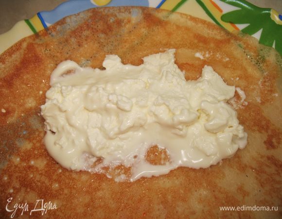 Смешиваем творог со сметаной (если творог кисловат можно добавить сахар).
Выкладываем столовую ложку творога на блин и скручиваем его.