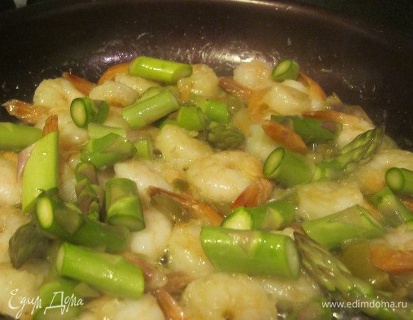 Оливки и чеснок раздавить ножом и обжарить 2 минуты на оливковом масле, добавить креветки, порезанный кальмар, спаржу и ожаривать 2 минуты, добавить кокосое молоко, немного порезанного базилика, соль и перец.Тушить 3 минуты.