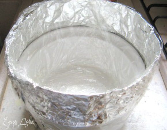 Обернуть её двойным слоем фольги, удвоив её высоту. Закрепить фольгу клейкой лентой. Высота в итоге не должна быть меньше 20 см. Изнутри форму тоже выложить пергаментом или целофаном, чтобы можно было легко достать готовый десерт.

