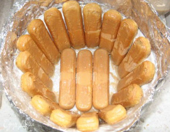 Обмакнуть савоярди в ликёр (по желанию) и выложить ими дно и стенки формы.