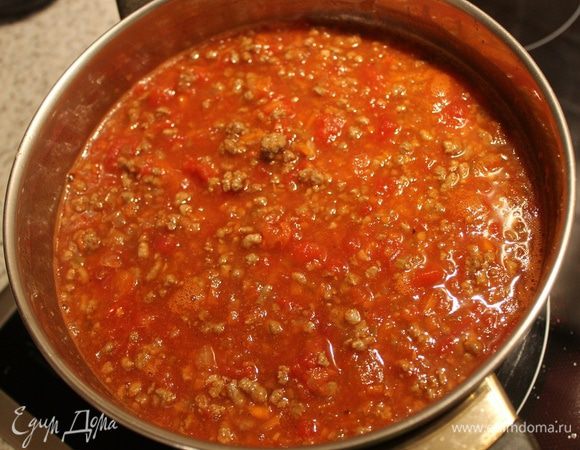 Влейте в сотейник белое вино, дайте ему выпариться. Добавьте помидоры в собственном соку, сахар, воду и размешайте. Оставьте тушиться на тихом огне около 2 часов. В конце добавьте травы, посолите, поперчите.
