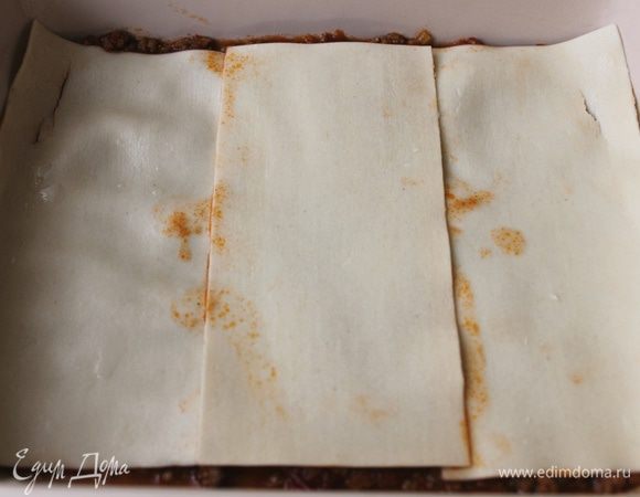 Выложите на дно немного рагу. На него уложите встык 3 пласта теста.